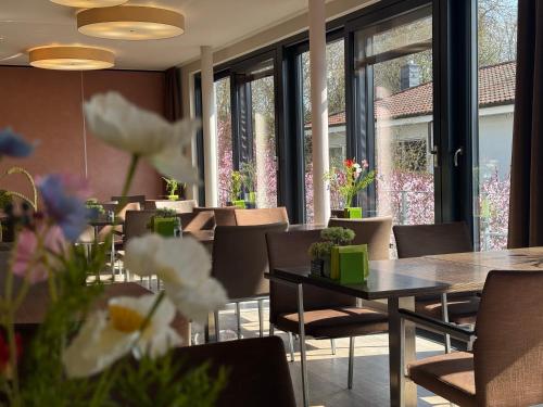 a dining room with tables and chairs and windows at ART-Hotel Braun in Kirchheimbolanden
