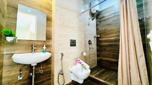 a bathroom with a sink and a toilet and a shower at BluO Lake View Studio - NewTown - Terrace Garden in Kolkata