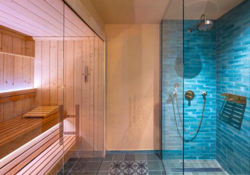 a bathroom with a shower with blue tiles at Le Marrakech Boutique Hotel in Kleinblittersdorf