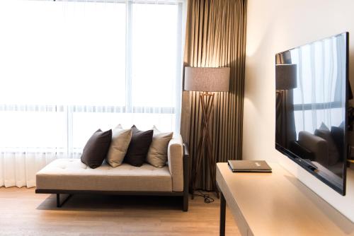 a living room with a couch and a television at Hotel Nanta Jeju in Jeju
