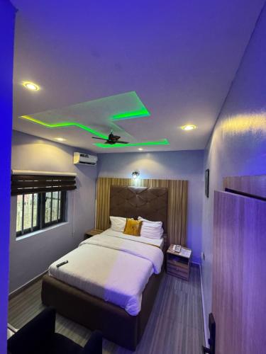 a bedroom with a bed with a green ceiling at Clisamnoris Hotel limited in Diobu