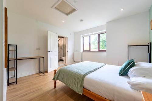 a white bedroom with a large bed and a window at The Elements Residence in Chepstow