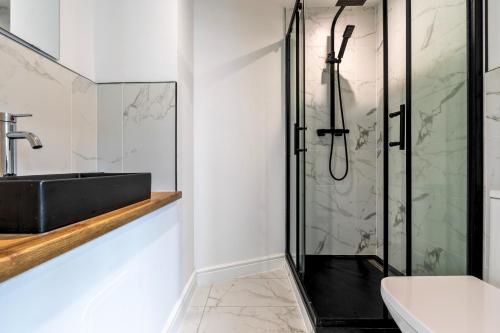 a bathroom with a glass shower and a sink at The Elements Residence in Chepstow