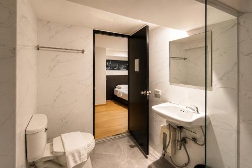 a bathroom with a toilet and a sink and a mirror at The Blocks Hostel Sukhumvit 10 in Bangkok