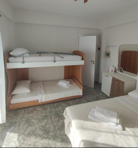 a room with two bunk beds and a mirror at Blackeye Hidden cottage in Nea Potidaea