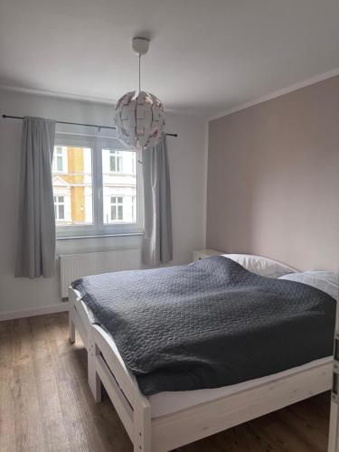 a bedroom with a bed and a chandelier at Stadttor Quartier Puschkinstrasse 58, Lutherstadt Wittenberg in Lutherstadt Wittenberg