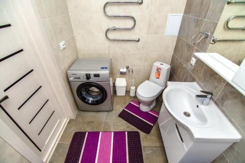 La salle de bains est pourvue d'un lave-linge et d'un lavabo. dans l'établissement Apartments Promenade Expo, à Astana