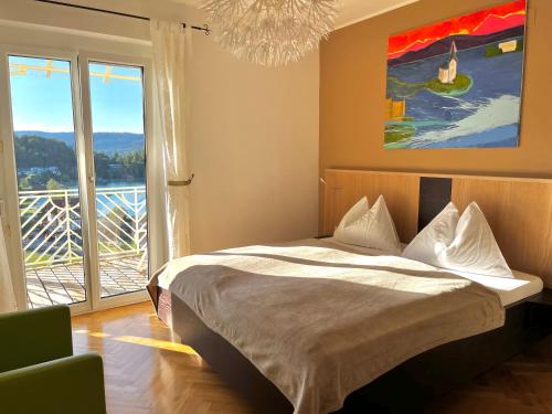 a bedroom with a bed and a large window at Buchenheim Apartments in Reifnitz
