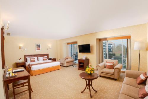 a hotel room with a bed and a living room at MGM Mark Whitefield in Bangalore