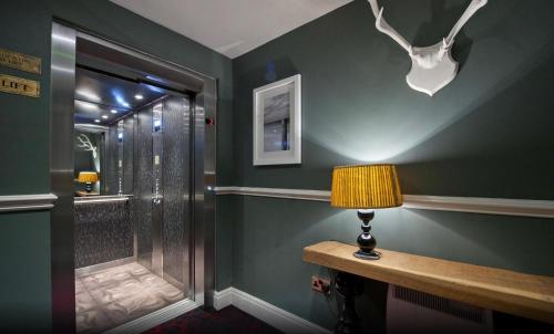 a bathroom with a shower with a lamp on a table at The Saltoun Inn in Fraserburgh