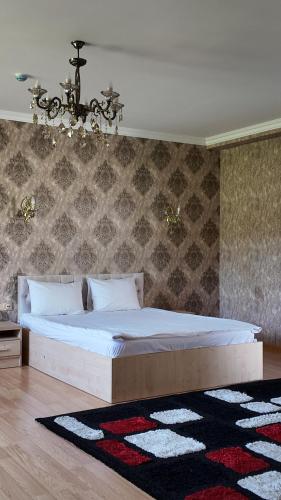 a bedroom with a large bed and a chandelier at Sadaxlı Hotel & Restaurant in Şǝrǝdil