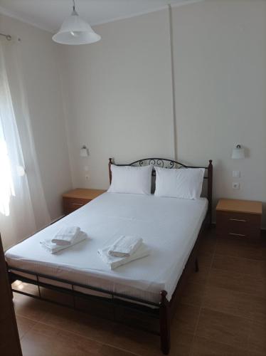 a bedroom with a bed with two towels on it at Betty's Seaside Olive House in Ofrínion