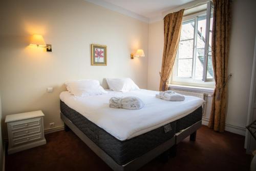 a bedroom with a bed with two towels on it at L'Univers Arras by Elema Hotels ex Hôtel de l'Univers Arras in Arras