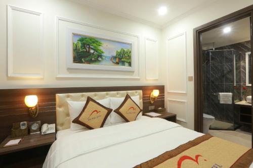 a bedroom with a large bed and a bathroom at Dai Phat Luxury Hotel & Apartment in Hanoi