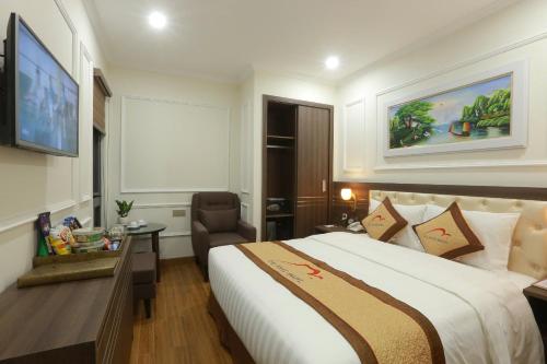 a hotel room with a bed and a desk and a chair at Dai Phat Luxury Hotel & Apartment in Hanoi
