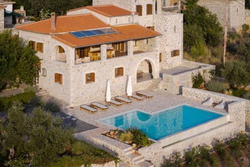 an aerial view of a house with a swimming pool at Pirgos Petropoulea in Poliána