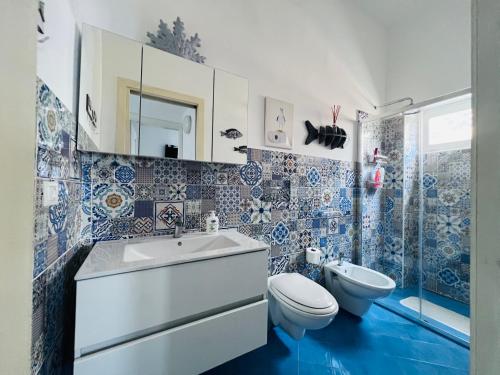a blue and white bathroom with a toilet and a sink at Le casette di nonna Giulia B in Lingua