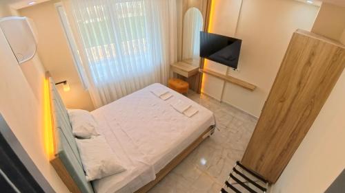 a small bedroom with a bed and a television at Hillfort Suites Apart Otel in Demre