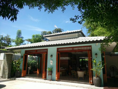 a building with glass doors and a roof at Bann Vimansamutr in Cha Am