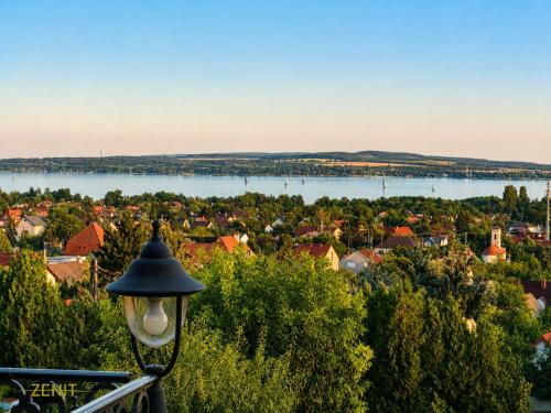 a street light with a view of a town and water at Zenit Wellness Hotel Balaton in Vonyarcvashegy