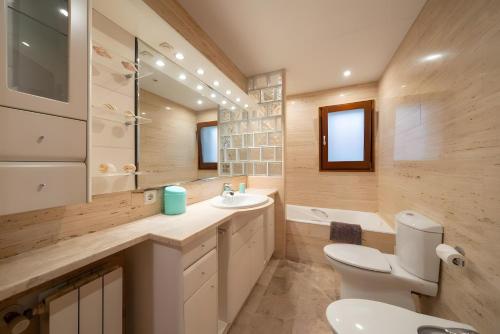 a bathroom with a white toilet and a sink at Can Jeroni in Figueres