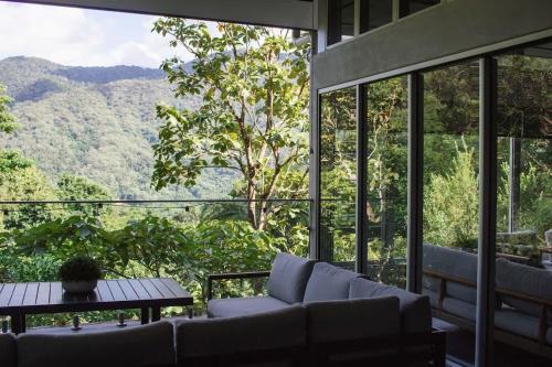 a living room with a couch and a table at Rainforest Retreat - Pool W Stunning Views in Redlynch