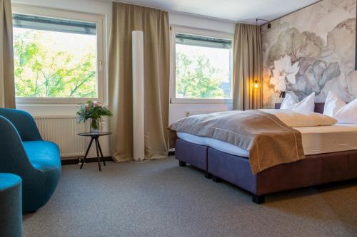 a bedroom with a large bed and a blue chair at Haus der Begegnung in Innsbruck