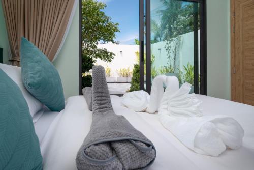 a bed with white towels and socks on it at Turtle Tales - Tao Yaa in Thai Muang