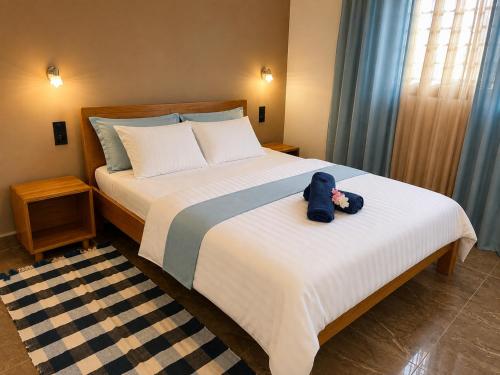 a bedroom with a bed with a stuffed animal on it at Le havre des palmiers in Tsivonoabe