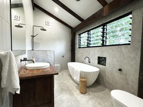 a bathroom with a large tub and a sink at The Treehouse - Rainforest Home - Pool in Smithfield