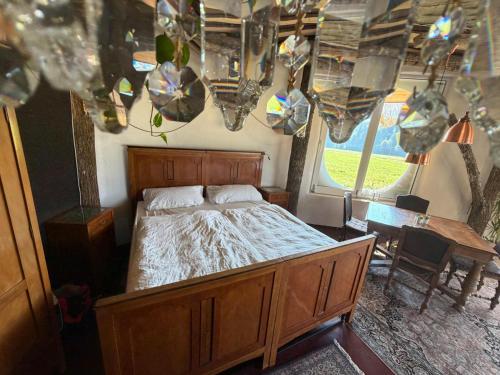 a bedroom with a bed and a table and a chandelier at EinBaumHaus Wörthersee in Auen