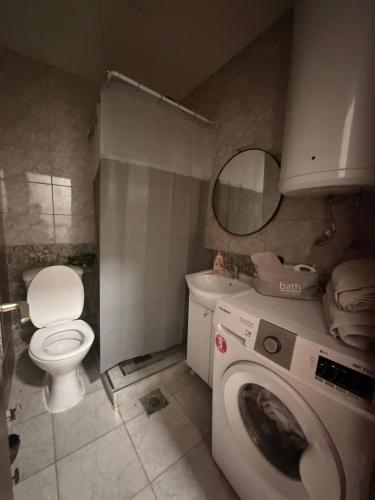 a bathroom with a toilet and a washing machine at Mia’s duplex apartment in Skopje