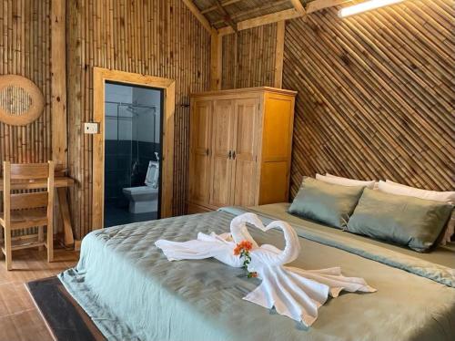a bedroom with a bed with a swan decoration on it at Dung Hoa Resort 