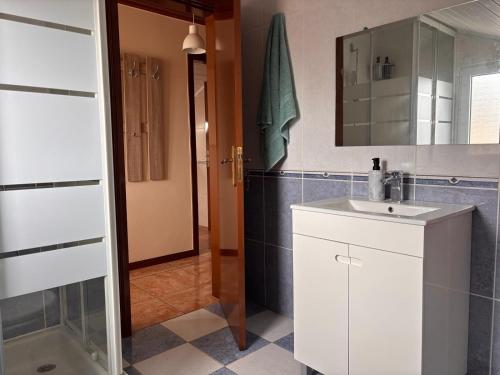 a bathroom with a white sink and a mirror at Tina's Place in Machico