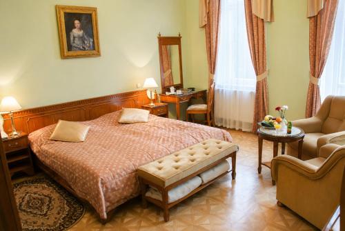 a bedroom with a bed and a couch and a chair at Bristol Kralovska Vila in Karlovy Vary
