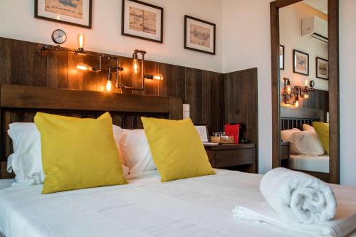 a bedroom with a bed with yellow pillows and a mirror at Captain Stam Suites Athens - CityStudio in Athens