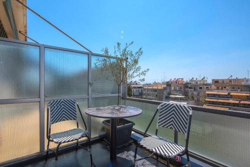 a balcony with two chairs and a table on a balcony at Captain Stam Suites Athens - CityStudio in Athens