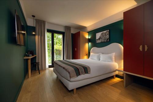 a bedroom with a white bed and green walls at Hôtel Restaurant la Couronne in Chamonix