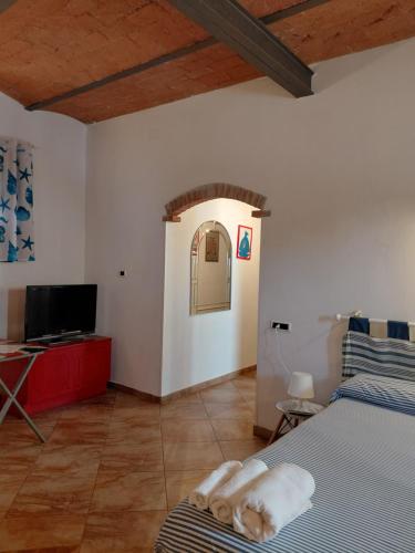 a bedroom with a bed and a flat screen tv at Il Gelso Casa Vacanze in Piombino