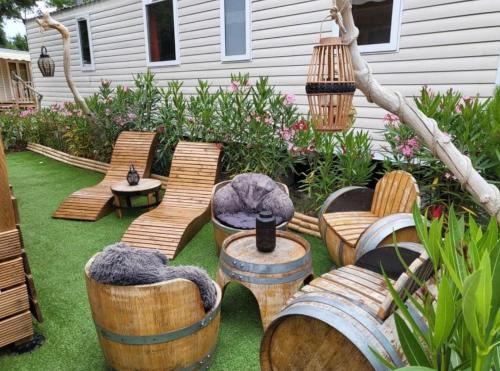 a backyard with wooden chairs and tables and a yard at Floriane in Claouey