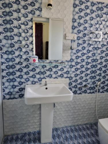 a bathroom with a sink and a mirror at Wings Hotel & Hostel in Trincomalee