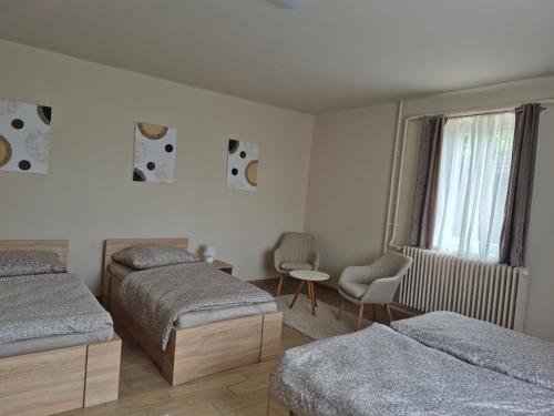 a bedroom with two beds and a window at Kriszta Gold Vendégház in Újfehértó