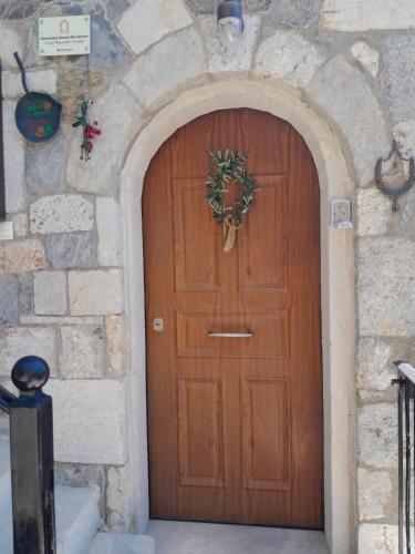a wooden door with a wreath on it at Stemnitsa Stone Residence - Cosy Mountain Escape in Stemnitsa