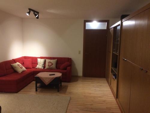 a living room with a red couch and a table at Grubhof in Sankt Martin bei Lofer