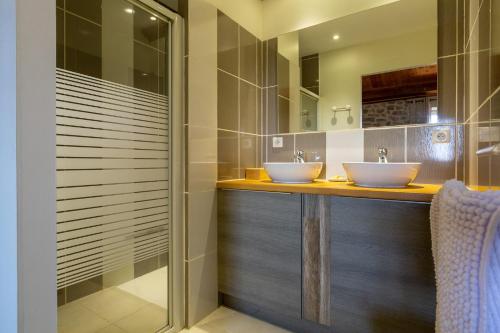two sinks in a bathroom with two mirrors at Les Combes Claires in Saint-Julien-Labrousse