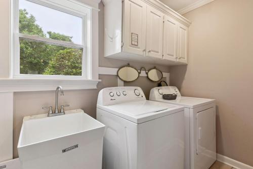 a laundry room with a washer and dryer and a window at A Wave From It All - 811 Ocean Blvd in Saint Simons