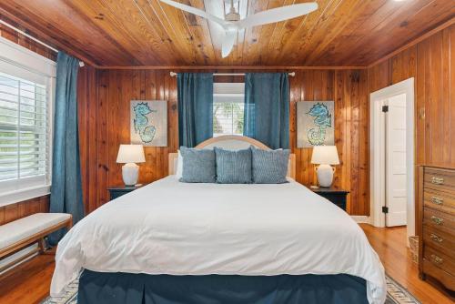 a bedroom with a large bed and wooden walls at A Wave From It All - 811 Ocean Blvd in Saint Simons