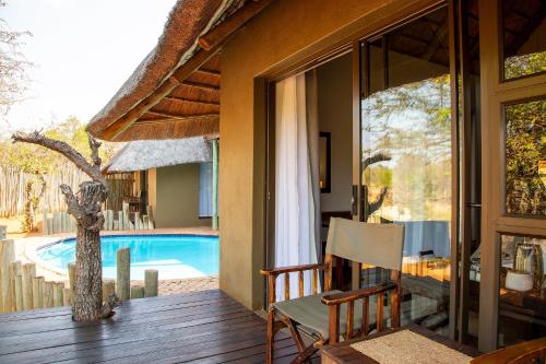 a porch of a house with a view of a swimming pool at Lions Place in Grietjie Game Reserve