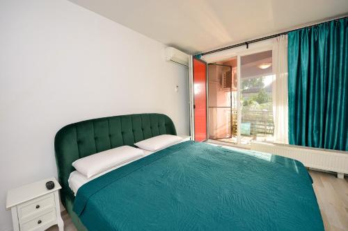 a bedroom with a green bed and a window at Harmony Suites in Bucharest