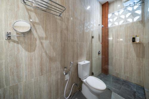 a bathroom with a toilet and a shower at Uluran Villa Uluwatu in Uluwatu